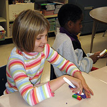 Student building shapes with cubes