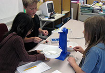 Students measuring using pan balance