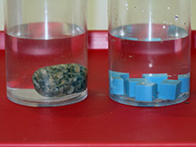 Rock and cube replica in water