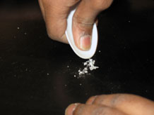 Hands crushing salt with spoon