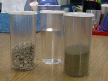 3 containers filled with sand, gravel, and water