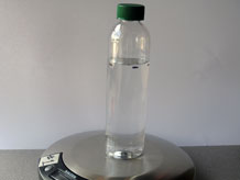 Bottle filled with water on scale