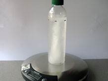 Bottle on scale filled with frozen water 